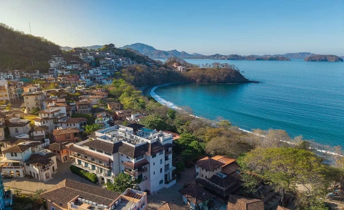 Sunny coastal view of Las Catalinas, Costa Rica with Mediterranean architecture, coastline, and water