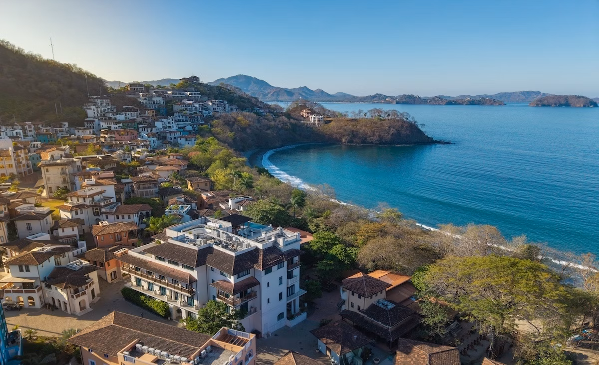 Sunny coastal view of Las Catalinas, Costa Rica with Mediterranean architecture, coastline, and water