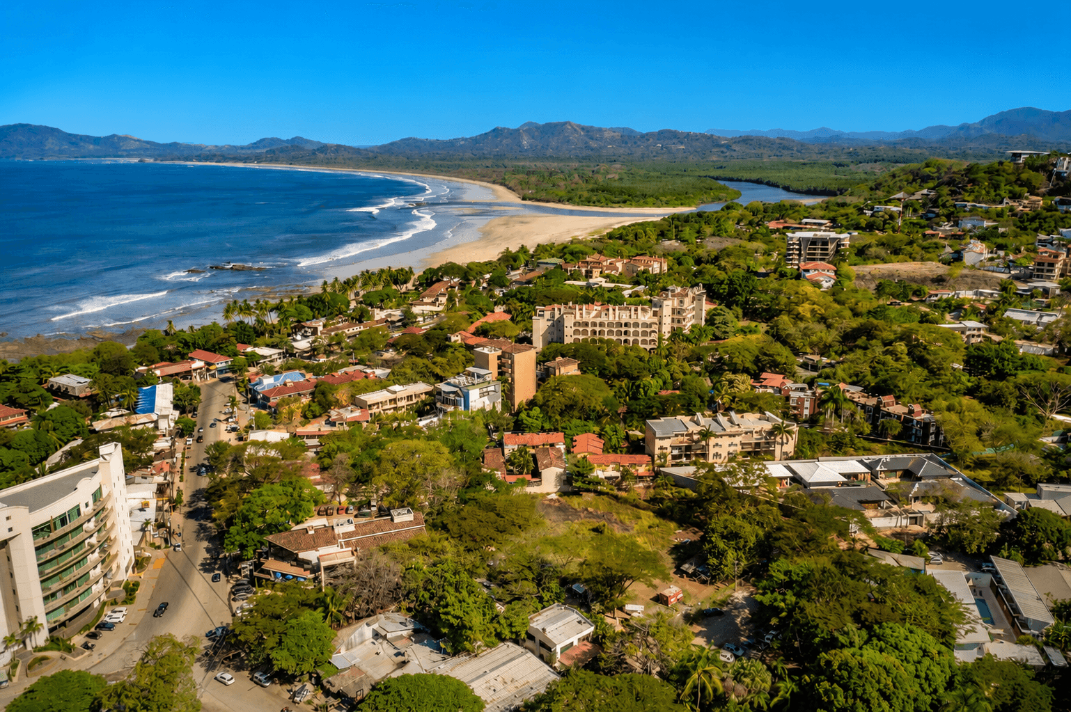 Aerial view of Tamarindo beach town with Pacific coastline and tropical hills in Costa Rica